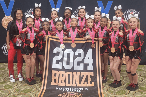 Envy Cheer Youth level 3 team at All Star Worlds with their bronze banner